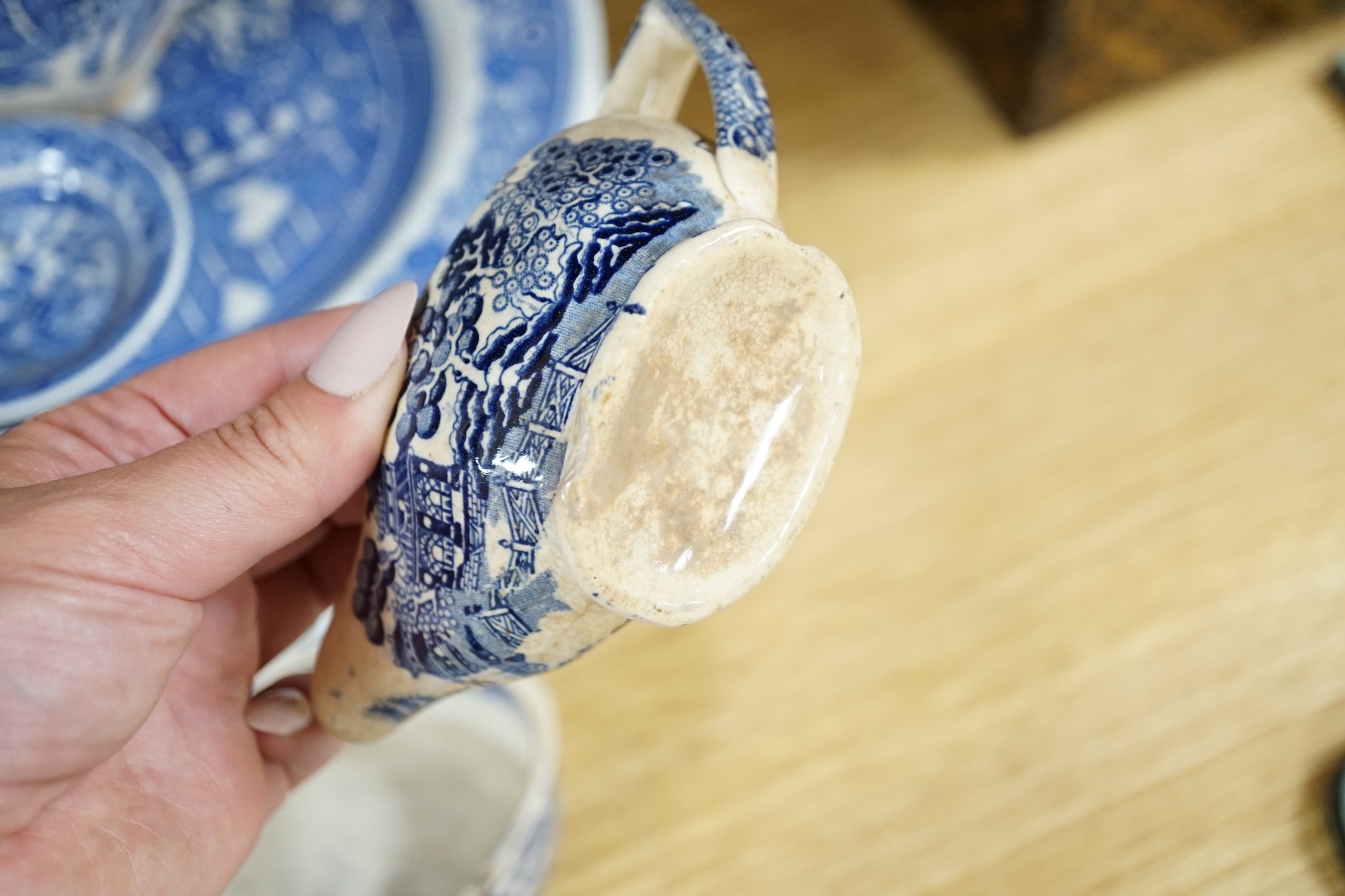 A mixed collection of Willow pattern blue and white dinnerware, including four tureens and covers, plates meat dishes etc. (large quantity). Condition - varied poor to fair to good